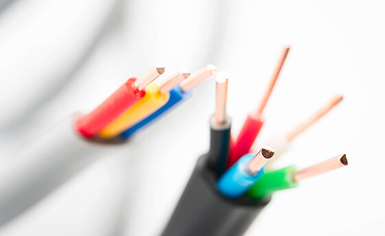 [Translate to German:] a close-up photo of 2 open cables with different colored copper wires