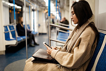 Transportation: a woman holding a phone in the subway